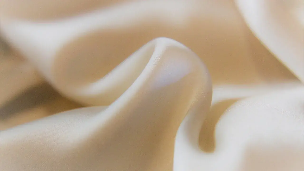 Sanfter Stoff in Beige, der sich sanft kräuselt. Ideal, um statische Aufladung zu verhindern und ein angenehmes Tragegefühl zu gewährleisten.