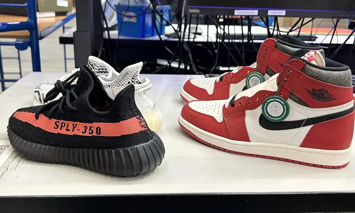 Zwei Paar Sneaker: ein schwarzer Yeezy Boost 350 mit rotem Streifen und ein weiß-roter Air Jordan 1. So erkennt man off white fake.
