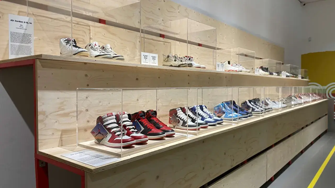 Ausstellung von Air Jordan Sneakern in einem modernen Sneaker Zimmer. Verschiedene Modelle sind auf Holzregalen hinter Glas ausgestellt.