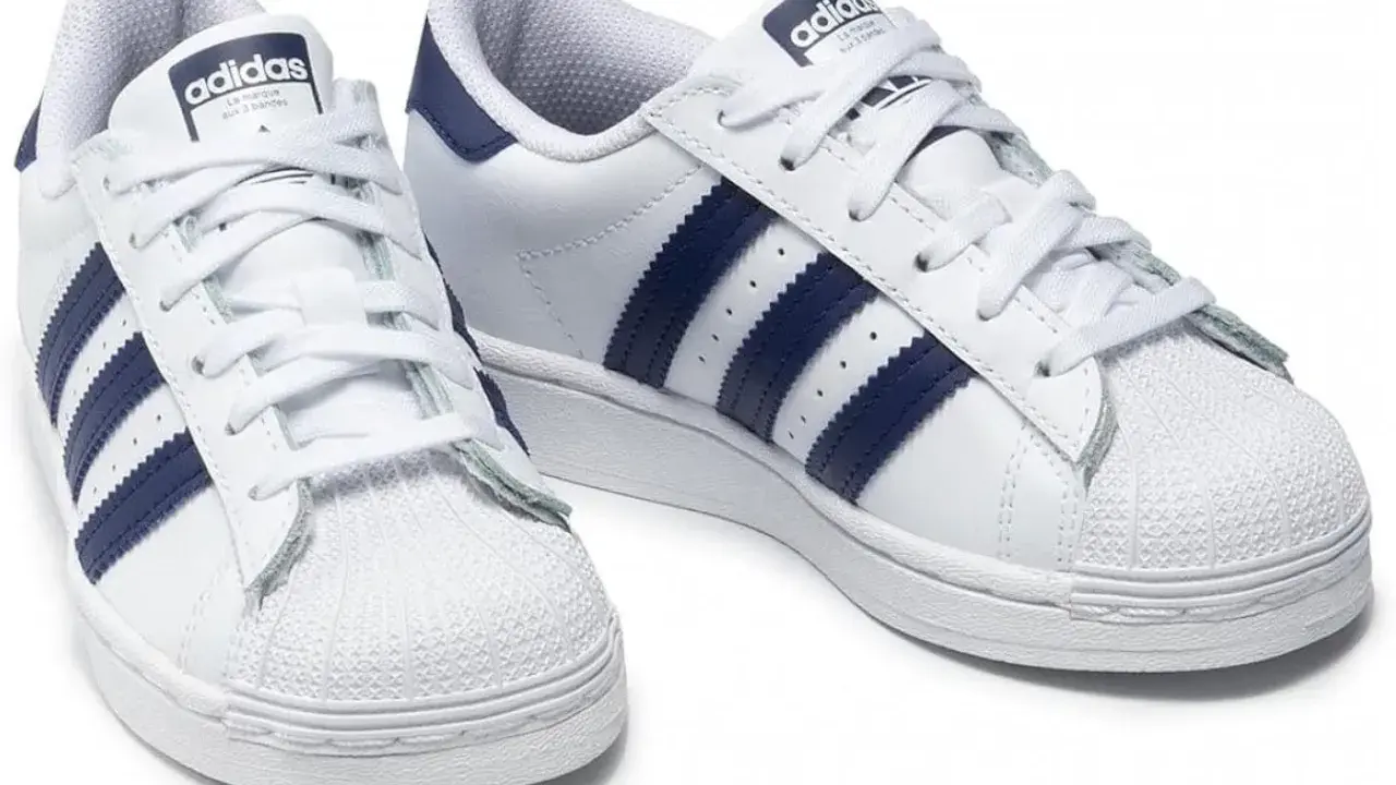 Weiße Adidas Superstar Sneaker mit dunkelblauen Streifen, made in Indonesia.