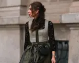 Eine Frau trägt eine graue Weste über einer schwarzen Spitzenbluse. So lässt sich die schwarze Bluse kombinieren für einen modernen Look.