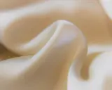 Sanfter Stoff in Beige, der sich sanft kräuselt. Ideal, um statische Aufladung zu verhindern und ein angenehmes Tragegefühl zu gewährleisten.