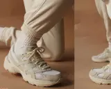 Beige Sneaker kombinieren: Ein lässiger Look mit cremefarbenen Jogginghosen und weißen Socken.