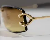 Elegante goldene Sonnenbrille mit braunen Gläsern. Ein Detail zeigt das C-förmige Design, das für einen Cartier serial number check relevant sein könnte.