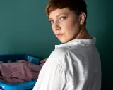 Frau mit Wäschekorb, bereit, Polyester zu waschen.