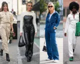 Vier Frauen präsentieren Outfits: Beige Utility-Overall, schwarzer Leder-Latzanzug mit Strick-Crop-Top, Jeans-Overall mit passender Jacke und weißer Overall mit grüner Tasche.