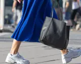 Ein blaues Kleid mit weißen Sneakern zum Kleid und einer schwarzen Tasche.