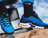 Blaue Nike TNs mit schwarzen Akzenten und goldenem Swoosh. Ein Blick auf die Details hilft, nike tn fake erkennen.