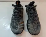 Zwei adidas bb3900 Laufschuhe mit grauem Camouflage-Muster und goldenen Streifen.