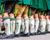 Herren in Lederhosen und traditionellen Strümpfen tragen passende Schuhe. Welche Schuhe zur Lederhose Herren? Schwarze Trachtenschuhe sind hier die Wahl.