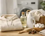 Alles für das Waschen von Hoodies: ein gefalteter Hoodie, Waschmittel, Seifen Nüsse und eine Bürste.