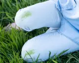 Hose mit grünen Grasflecken im Gras. Tipps zum Grasflecken entfernen gesucht?