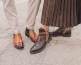 Zwei Paar elegante Schuhe: braune Budapester mit Flügelspitzen und Chelsea-Boots mit Leopardenmuster.