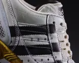 Detailaufnahme des Adidas ZX 8000 Release. Der Schuh zeigt die charakteristischen Streifen und eine goldene Sohle.