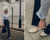 Schicke Loafer sind die perfekte Wahl für 3/4 Hosen. Eine Frau in einem gestreiften Hemd und dunklen Hosen trägt cremefarbene Loafer.