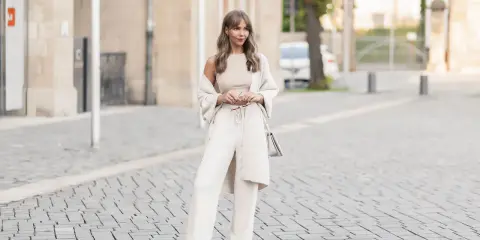 Eine Frau in einem cremefarbenen Outfit mit weiten Leinenhosen, das perfekt für den Sommer ist. So kann man Leinenhose kombinieren Damen!
