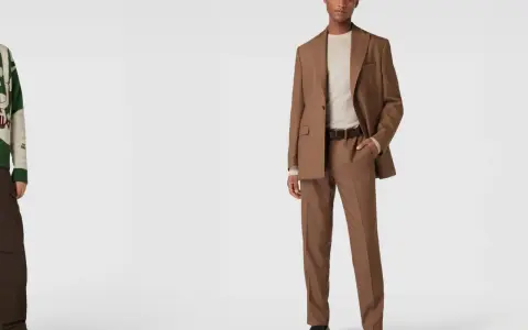 Mann in brauner Hose und Sakko, dazu ein helles Hemd. Ein stilvolles Outfit, das zeigt, wie man eine braune Hose kombinieren kann.