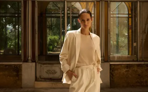 Eine Frau in einem beigen Blazer und passender Hose, die zeigt, wie man einen blazer beige kombinieren kann.