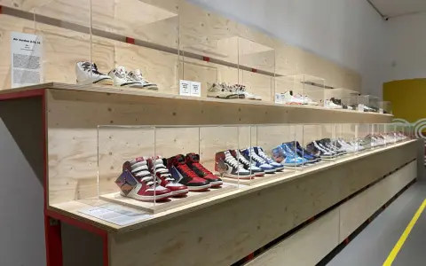 Ausstellung von Air Jordan Sneakern in einem modernen Sneaker Zimmer. Verschiedene Modelle sind auf Holzregalen hinter Glas ausgestellt.