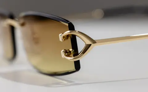 Elegante goldene Sonnenbrille mit braunen Gläsern. Ein Detail zeigt das C-förmige Design, das für einen Cartier serial number check relevant sein könnte.