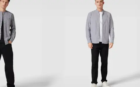Zwei Männer in grauen Hemden mit Stehkragen und schwarzen Hosen. Welches graues Hemd passt besser zum Anzug?