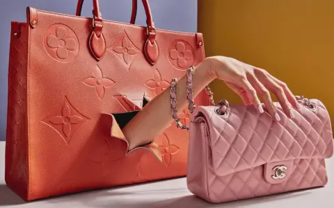 Vergleich: Louis Vuitton Replica vs. authentische Tasche. Eine Hand greift aus einer großen orangefarbenen Tasche nach einer kleinen rosa gesteppten Tasche.