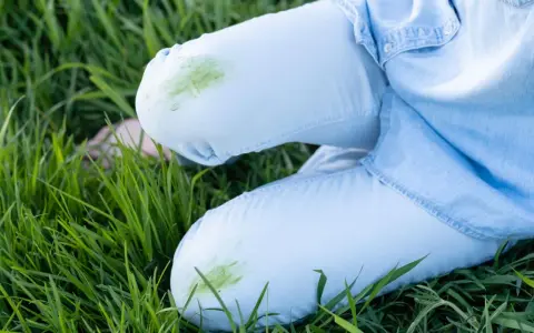 Hose mit grünen Grasflecken im Gras. Tipps zum Grasflecken entfernen gesucht?