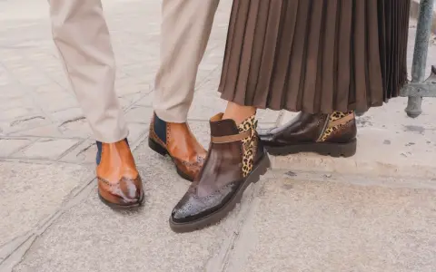 Zwei Paar elegante Schuhe: braune Budapester mit Flügelspitzen und Chelsea-Boots mit Leopardenmuster.