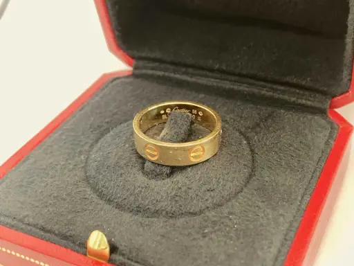 Goldener Cartier Ring in roter Schatulle. Achten Sie auf Details, um ein Cartier Armband Fake erkennen zu können.