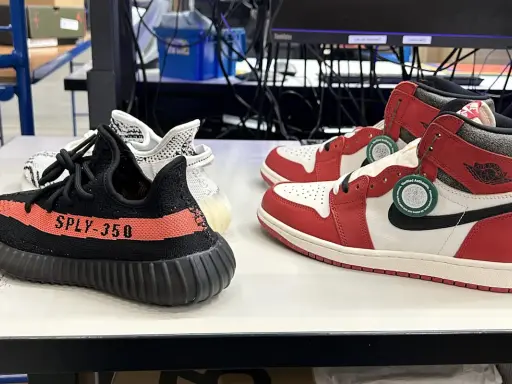 Zwei Paar Sneaker: ein schwarzer Yeezy Boost 350 mit rotem Streifen und ein weiß-roter Air Jordan 1. So erkennt man off white fake.