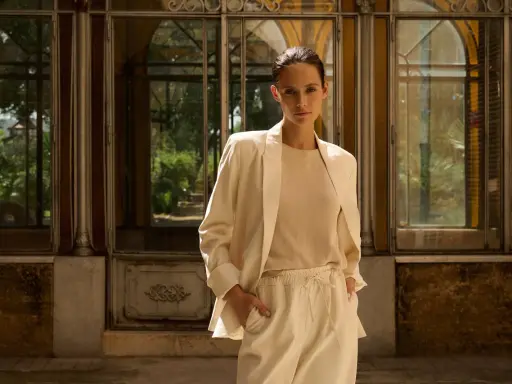 Eine Frau in einem beigen Blazer und passender Hose, die zeigt, wie man einen blazer beige kombinieren kann.