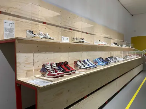 Ausstellung von Air Jordan Sneakern in einem modernen Sneaker Zimmer. Verschiedene Modelle sind auf Holzregalen hinter Glas ausgestellt.