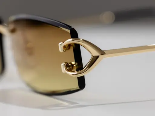 Elegante goldene Sonnenbrille mit braunen Gläsern. Ein Detail zeigt das C-förmige Design, das für einen Cartier serial number check relevant sein könnte.