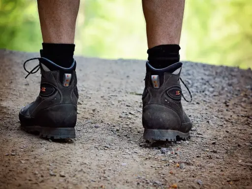 Robuste Wanderschuhe auf einem Schotterweg, bereit für jedes Abenteuer. Diese schuhe die lange halten, sind ein treuer Begleiter.