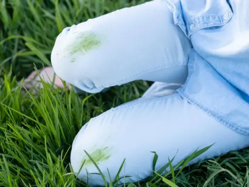 Hose mit grünen Grasflecken im Gras. Tipps zum Grasflecken entfernen gesucht?