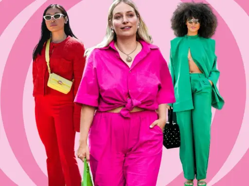 Drei Frauen in auffälligen, monochromen Outfits: Rot, Pink und Grün. Sie präsentieren selbstbewusst ihre Looks.