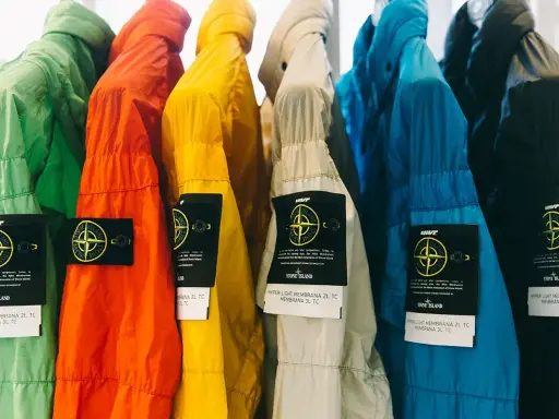Bunte Stone Island Jacken mit dem ikonischen Patch. Ein Vergleich von Stone Island Patch original vs. fake ist hier gut erkennbar.