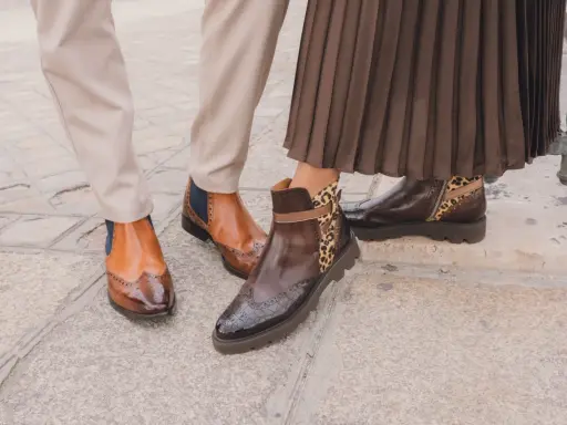 Zwei Paar elegante Schuhe: braune Budapester mit Flügelspitzen und Chelsea-Boots mit Leopardenmuster.