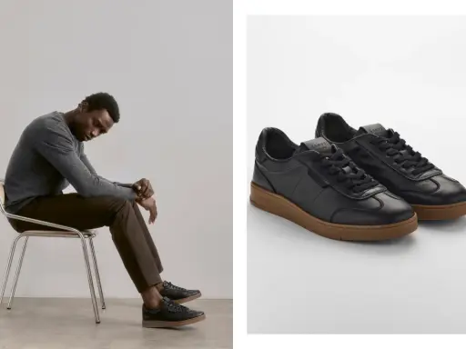 Mann sitzt nachdenklich auf einem Stuhl, trägt schwarze Sneaker mit brauner Sohle. So sollten Schuhe sitzen: bequem und stilvoll.