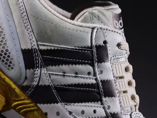 Detailaufnahme des Adidas ZX 8000 Release. Der Schuh zeigt die charakteristischen Streifen und eine goldene Sohle.