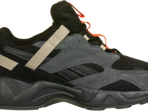 Reebok Aztrek 96: schwarzer Sneaker mit grauen Wildleder-Overlays, beige Akzenten und orangefarbenen Schlaufen.