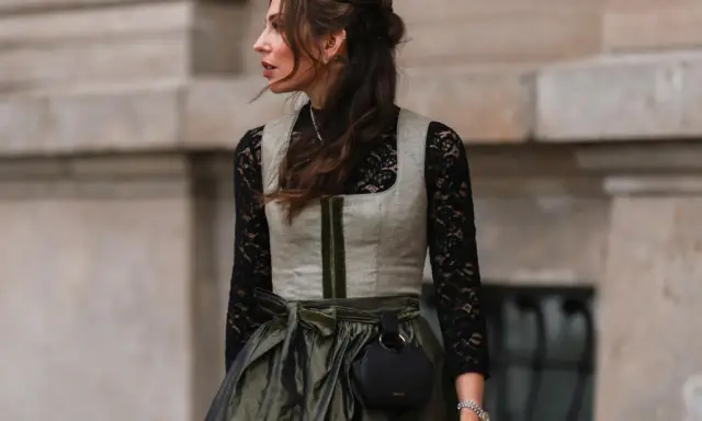 Eine Frau trägt eine graue Weste über einer schwarzen Spitzenbluse. So lässt sich die schwarze Bluse kombinieren für einen modernen Look.