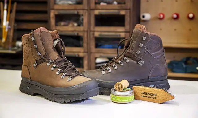 Braune Wanderschuhe, daneben ein Wachs und eine Bürste zur Pflege. So bleiben deine adidas Terrex Stiefel wie neu, auch nach der nächsten "Waschmaschine" aus Schlamm und Matsch.