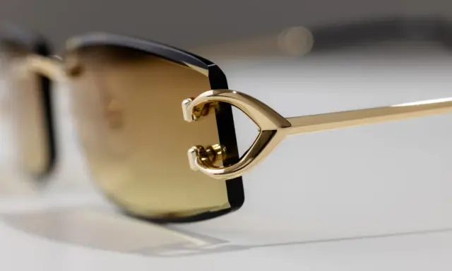 Elegante goldene Sonnenbrille mit braunen Gläsern. Ein Detail zeigt das C-förmige Design, das für einen Cartier serial number check relevant sein könnte.
