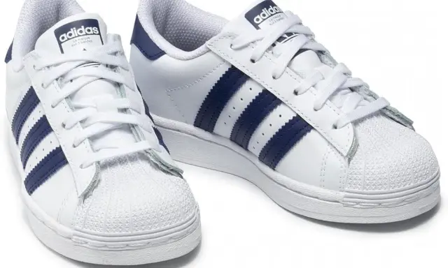 Weiße Adidas Superstar Sneaker mit dunkelblauen Streifen, made in Indonesia.