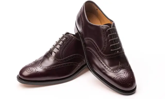 Elegante, dunkelbraune Herrenschuhe im **full brogue** Stil mit Lochmuster und Schnürung.