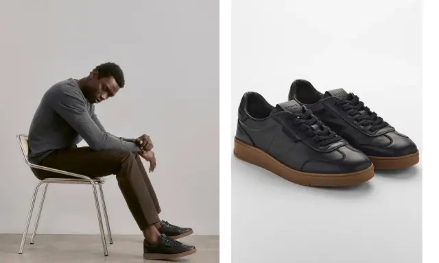 Mann sitzt nachdenklich auf einem Stuhl, trägt schwarze Sneaker mit brauner Sohle. So sollten Schuhe sitzen: bequem und stilvoll.