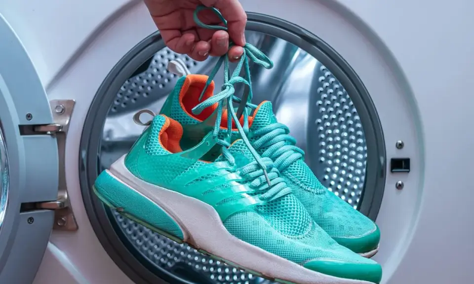 Skechers waschen wieviel Grad? Türkise Turnschuhe werden vor dem Waschen in der Waschmaschine gehalten.