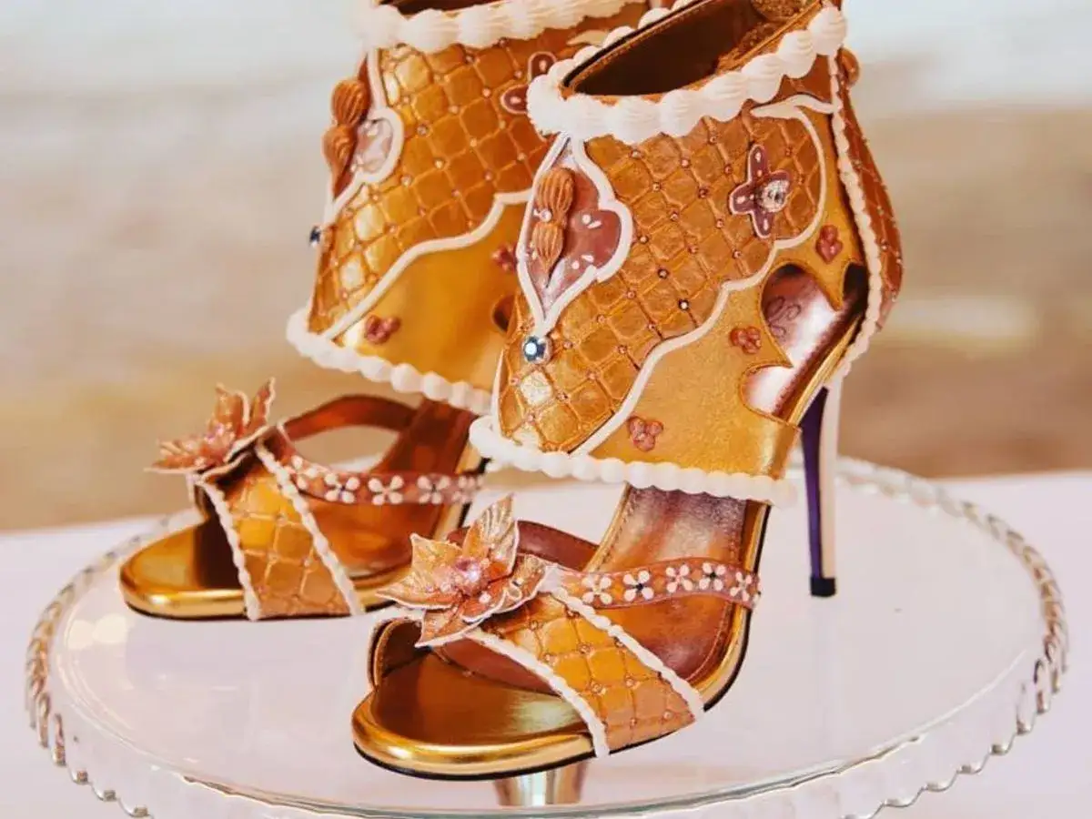 Goldene Sandalen und Stiefel, verziert mit Zuckerguss und Blumen, sehen aus wie die teuersten Schuhe der Welt, ein süßer Traum.