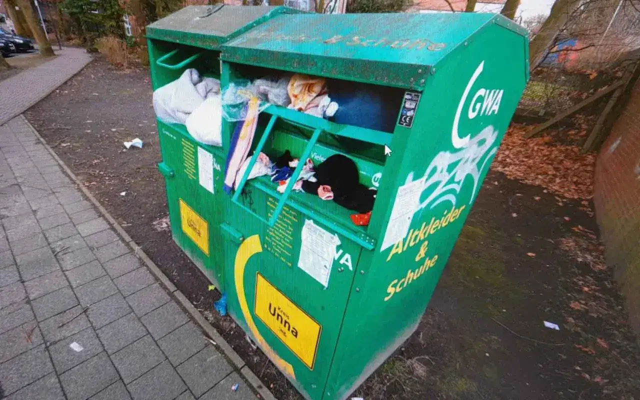 Grüne Sammelbox für Altkleider und Schuhe. Hier können Sie Ihre alten Sachen abgeben, um sie recyceln zu lassen.